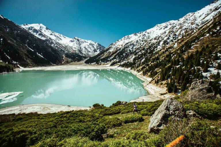 Coureurs de trail sur les sentiers alpins autour d’un lac, dans une ambiance de début d’été.