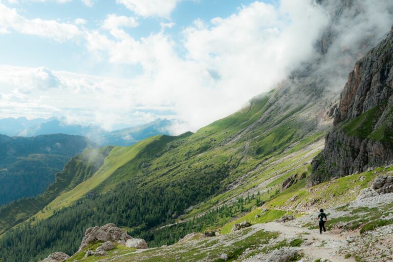 Traileur courant sur un sentier de montagne dans les Dolomites avant un objectif estival.
