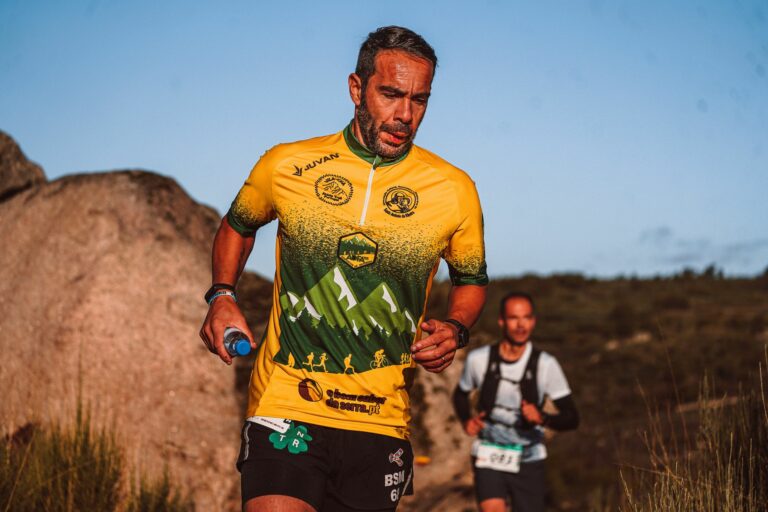 Traileur ajustant son hydratation lors d’une course longue en montagne